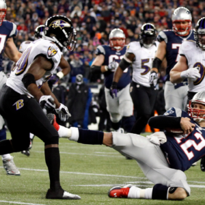 Jan 20, 2013; Foxboro, MA, USA; New England Patriots quarterback Tom Brady (12) slides to avoid a hit from Baltimore Ravens free safety Ed Reed (20) during the second quarter of the AFC championship game at Gillette Stadium. Mandatory Credit: David Butler II-Imagn Images