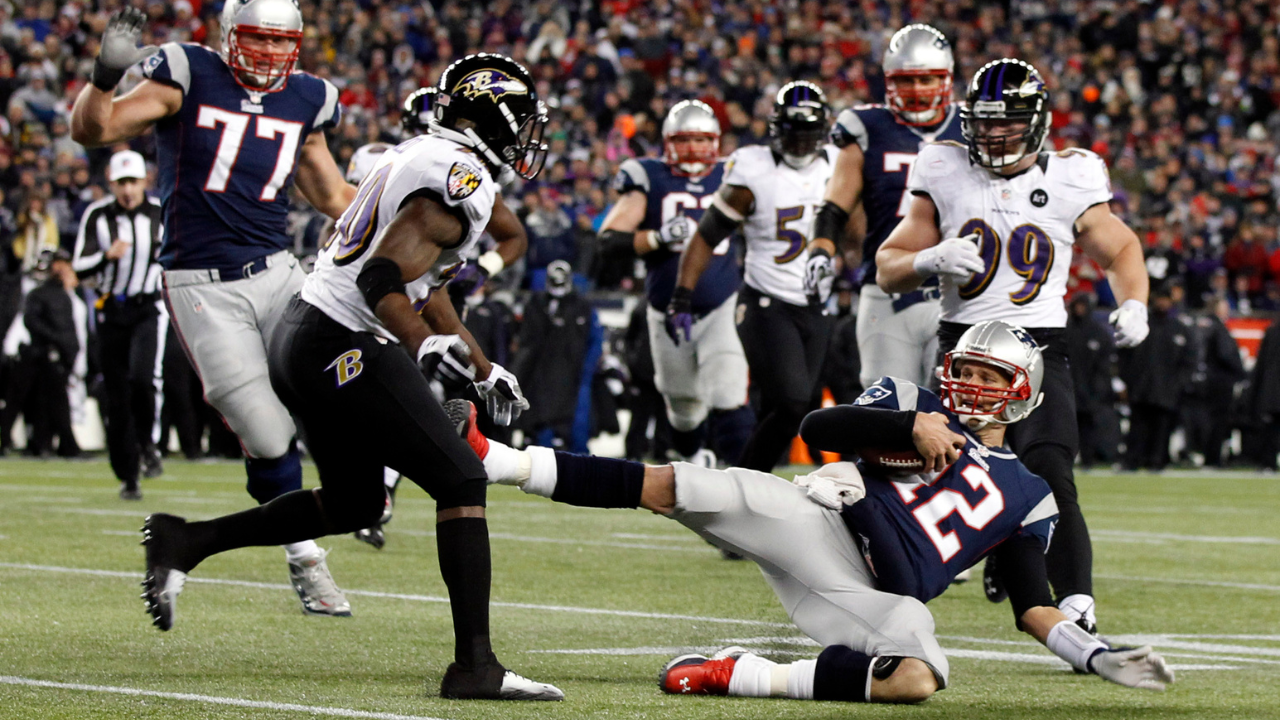Jan 20, 2013; Foxboro, MA, USA; New England Patriots quarterback Tom Brady (12) slides to avoid a hit from Baltimore Ravens free safety Ed Reed (20) during the second quarter of the AFC championship game at Gillette Stadium. Mandatory Credit: David Butler II-Imagn Images