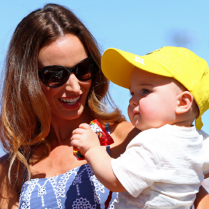 Mar 13, 2016; Avondale, AZ, USA; Samantha Busch , wife of NASCAR Sprint Cup Series driver Kyle Busch (not pictured) holds son Brexton Busch during the Good Sam 500 at Phoenix International Raceway. Mandatory Credit: Mark J. Rebilas-Imagn Images