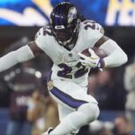 Baltimore Ravens running back Derrick Henry (22) carries the ball against cornerback Elijah Molden (22) in the second half at SoFi Stadium.