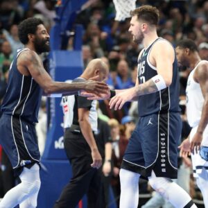 Dallas Mavericks guard Kyrie Irving (11) celebrates with Dallas Mavericks guard Luka Doncic (77) during the fourth quarter against the Memphis Grizzlies at American Airlines Center.