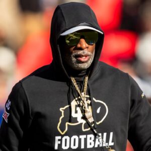 Colorado head coach Deion Sanders watches his players warmup prior to the game between the Kansas Jayhawks and the Colorado Buffaloes at GEHA Field at Arrowhead Stadium.