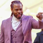 Commentator Richard Sherman signals to fans prior to a game between the Kansas City Chiefs and Las Vegas Raiders at GEHA Field at Arrowhead Stadium.