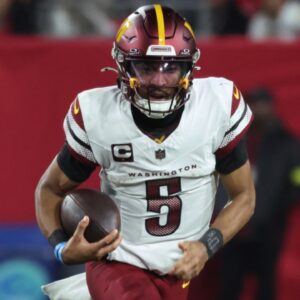 Jan 12, 2025; Tampa, Florida, USA; Washington Commanders quarterback Jayden Daniels (5) scrambles against Tampa Bay Buccaneers defensive tackle Calijah Kancey (94) during the second quarter of a NFC wild card playoff at Raymond James Stadium.