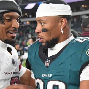 Washington Commanders quarterback Jayden Daniels (5) and Philadelphia Eagles running back Saquon Barkley (26) meet on the field after the game at Lincoln Financial Field.