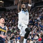 Minnesota Timberwolves guard Anthony Edwards (5) goes to the basket for a slam dunk over Denver Nuggets center Nikola Jokic (15) during the third quarter at Target Center.