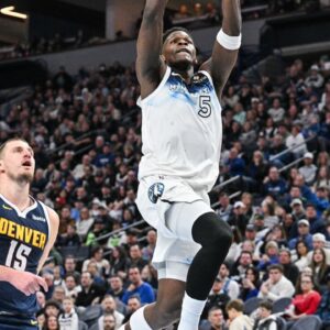 Minnesota Timberwolves guard Anthony Edwards (5) goes to the basket for a slam dunk over Denver Nuggets center Nikola Jokic (15) during the third quarter at Target Center.