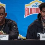 Colorado Buffaloes head coach Deion Sanders and quarterback Shedeur Sanders (2) talk with the media after the game against the Brigham Young Cougars at Alamodome.