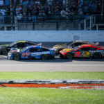Sep 29, 2024; Kansas City, Kansas, USA; NASCAR Cup Series driver Corey LaJoie (51) and driver Carson Hocevar (77) lead at the start of the third stage during the Hollywood Casino 400 at Kansas Speedway. Mandatory Credit: Amy Kontras-Imagn Images