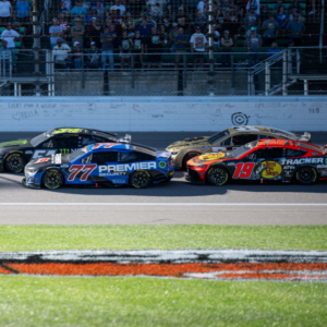 Sep 29, 2024; Kansas City, Kansas, USA; NASCAR Cup Series driver Corey LaJoie (51) and driver Carson Hocevar (77) lead at the start of the third stage during the Hollywood Casino 400 at Kansas Speedway. Mandatory Credit: Amy Kontras-Imagn Images