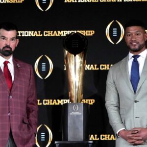 Ohio State Buckeyes head coach Ryan Day (left) and Notre Dame Fighting Irish head coach Marcus Freeman pose with the College Football Playoff National Championship trophy at press conference at The Westin Peachtree Plaza, Savannah Ballroom.