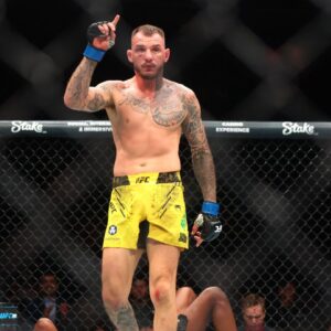 Renato Moicano (blue gloves) reacts after defeating Jalin Turner (red gloves) during UFC 300 at T-Mobile Arena.