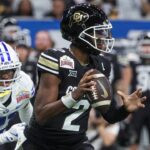 Dec 28, 2024; San Antonio, TX, USA; Colorado Buffaloes quarterback Shedeur Sanders (2) runs with the ball as Brigham Young Cougars cornerback Evan Johnson (21) attempts to make a tackle during the third quarter at Alamodome.
