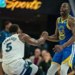 Golden State Warriors forward Draymond Green (23) helps up Minnesota Timberwolves guard Anthony Edwards (5) after being knocked down during the second quarter at Chase Center.