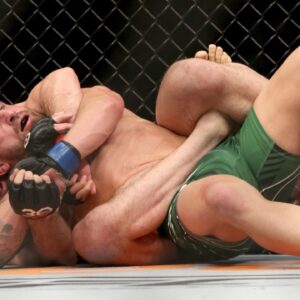 Islam Makhachev (red gloves) fights Alexander Volkanovski (blue gloves) during UFC 284 at RAC Arena.