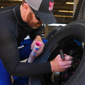 NAPA Autocare Chevrolet front tire changer Aaron Powell greases lug nuts n a wheel ahead of the NASCAR truck series race at the Circuit of the Americas on Saturday Mar. 25, 2023 in Austin.