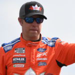 Jun 26, 2022; Nashville, Tennessee, USA; NASCAR Cup Series driver Brad Keselowski (6) waives to fans as he walks the stage during driver introductions before the Ally 400 at Nashville Superspeedway. Mandatory Credit: Christopher Hanewinckel-Imagn Images