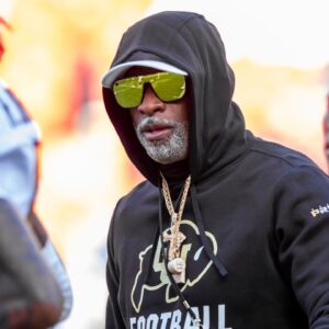 Colorado head coach Deion Sanders watches his players warmup prior to the game between the Kansas Jayhawks and the Colorado Buffaloes at GEHA Field at Arrowhead Stadium.