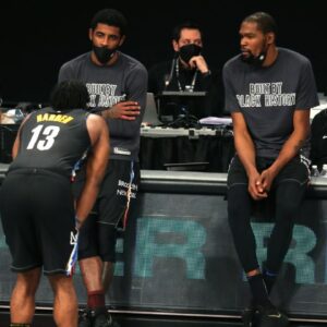 Brooklyn Nets point guard Kyrie Irving (C) and power forward Kevin Durant (R) talk to shooting guard James Harden (13) before checking into the game during the fourth quarter against the Los Angeles Clippers at Barclays Center.