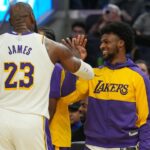 Los Angeles Lakers forward LeBron James (23) slaps hands with guard Bronny James (center right) during the third quarter against the Golden State Warriors at Chase Center