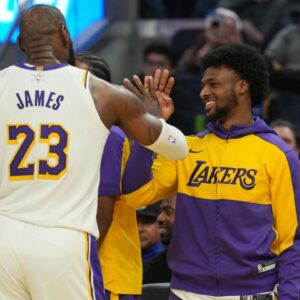 Los Angeles Lakers forward LeBron James (23) slaps hands with guard Bronny James (center right) during the third quarter against the Golden State Warriors at Chase Center