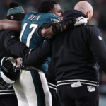 Philadelphia Eagles linebacker Nakobe Dean (17) is helped off the field against the Green Bay Packers during the first half in an NFC wild card game at Lincoln Financial Field.