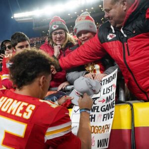 Kansas City Chiefs quarterback Patrick Mahomes (15) signs autographs for fans after the win over the Las Vegas Raiders at GEHA Field at Arrowhead Stadium.