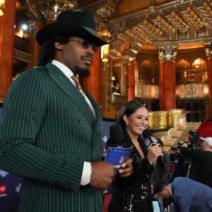 Former NFL quarterback Cam Newton and broadcaster Kaylee Hartung stand on the red carpet ahead of the 2024 NFL Draft at Detroit’s Fox Theatre.
