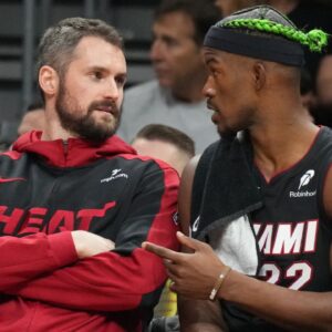 Miami Heat forward Jimmy Butler (22) talks with forward Kevin Love (42) on the bench during the second half against the Indiana Pacers at Kaseya Center.