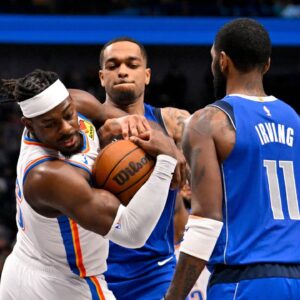 Oklahoma City Thunder guard Luguentz Dort (5) takes the ball away from Dallas Mavericks forward P.J. Washington (25) as guard Kyrie Irving (11) looks on during the second quarter at the American Airlines Center.