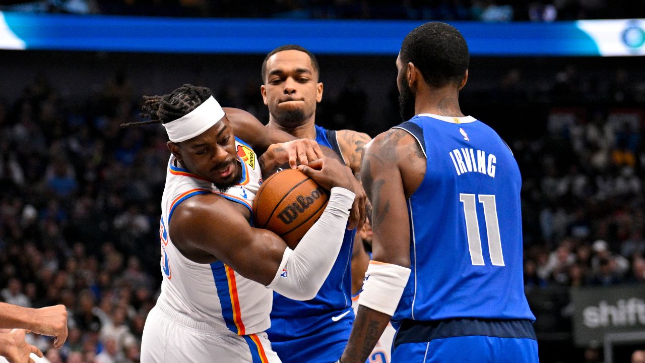 Oklahoma City Thunder guard Luguentz Dort (5) takes the ball away from Dallas Mavericks forward P.J. Washington (25) as guard Kyrie Irving (11) looks on during the second quarter at the American Airlines Center.