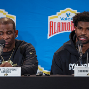 Colorado Buffaloes head coach Deion Sanders and quarterback Shedeur Sanders (2) talk with the media
