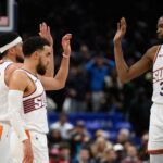 Phoenix Suns guard Tyus Jones (21), guard Devin Booker (1), and forward Kevin Durant (35) celebrate during the fourth quarter against the Washington Wizards at Capital One Arena.