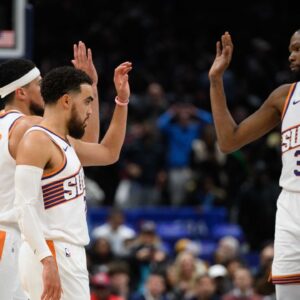 Phoenix Suns guard Tyus Jones (21), guard Devin Booker (1), and forward Kevin Durant (35) celebrate during the fourth quarter against the Washington Wizards at Capital One Arena.