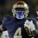 Notre Dame Fighting Irish running back Jeremiyah Love (4) scores a touchdown while being chased by Indiana Hoosiers defensive back D'Angelo Ponds (5) and Indiana Hoosiers defensive back Jamari Sharpe (22) during the first half of a game between the Indiana Hoosiers and the Notre Dame Fighting Irish in first round of the College Football Playoff on Friday, Dec. 20, 2024, in South Bend.