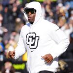 Colorado Buffaloes head coach Deion Sanders runs onto the field before the game against the Oklahoma State Cowboys at Folsom Field.