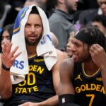 Golden State Warriors guard Stephen Curry (30) and guard Buddy Hield (7) talk on the bench during the second half against the Toronto Raptors at Scotiabank Arena.
