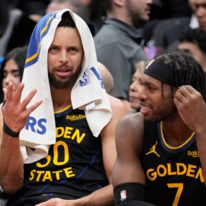 Golden State Warriors guard Stephen Curry (30) and guard Buddy Hield (7) talk on the bench during the second half against the Toronto Raptors at Scotiabank Arena.
