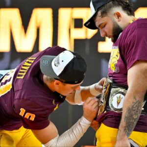 Arizona State Sun Devils quarterback Sam Leavitt (10) signs the WWE Big 12 championship belt of running back Cam Skattebo (4) celebrates after the Sun Devils defeat the Iowa State Cyclones and win the 2024 Big 12 Championship at AT&T Stadium.