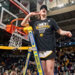 Iowa Hawkeyes guard Caitlin Clark (22) cuts down the net after beating LSU in the Elite 8 round of the NCAA Women's Basketball Tournament between Iowa and LSU at MVP Arena