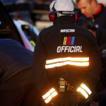 A NASCAR official watches on as team make adjust to their cars before the last change qualifying race for the Clash at Bowman Gray at Bowman Gray Stadium.