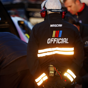 A NASCAR official watches on as team make adjust to their cars before the last change qualifying race for the Clash at Bowman Gray at Bowman Gray Stadium.