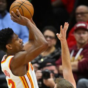 Atlanta Hawks forward De'Andre Hunter (12) shoots beside Cleveland Cavaliers guard Sam Merrill (5) in the fourth quarter at Rocket Mortgage FieldHouse