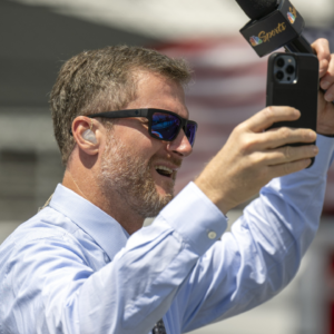 Dale Earnhardt Jr. raises his hands to cheering fans on the grid before the Verizon 200 at the Indianapolis Motor Speedway Road Course.