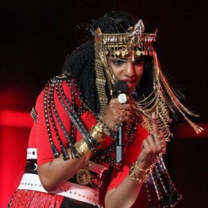 Recording artist MIA gestures towards the camera during the halftime show for Super Bowl XLVI between the New York Giants and New England Patriots at Lucas Oil Stadium.
