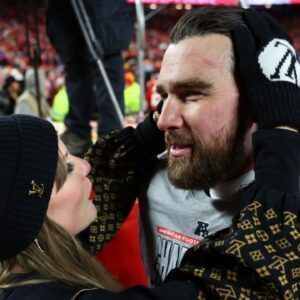 Recording artist Taylor Swift and Kansas City Chiefs tight end Travis Kelce (87) react after the AFC Championship game against the Buffalo Bills at GEHA Field at Arrowhead Stadium.