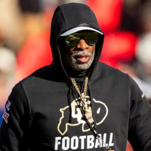 Colorado head coach Deion Sanders watches his players warmup prior to the game between the Kansas Jayhawks and the Colorado Buffaloes at GEHA Field at Arrowhead Stadium.