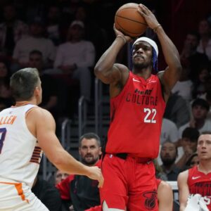 Miami Heat forward Jimmy Butler (22) shoots the ball against Phoenix Suns guard Grayson Allen (8) during the second half at Kaseya Center.