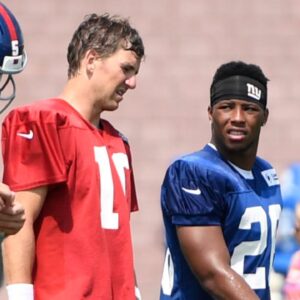 Aug 7, 2018; East Rutherford, NJ, USA; New York Giants quarterback Eli Manning (10) and rookie running back Saquon Barkley (26) talk on the field during training camp.