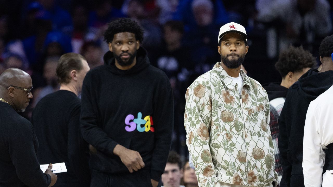 Injured Philadelphia 76ers Paul George (R) and Joel Embiid (L) look on during the first quarter against the Memphis Grizzlies at Wells Fargo Center